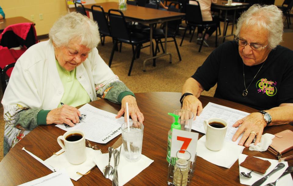 Margie Fritz (left) works on a word puzzle while Janet Klink checks out the senior center schedule of activities at the Somerset Senior Center. File photo