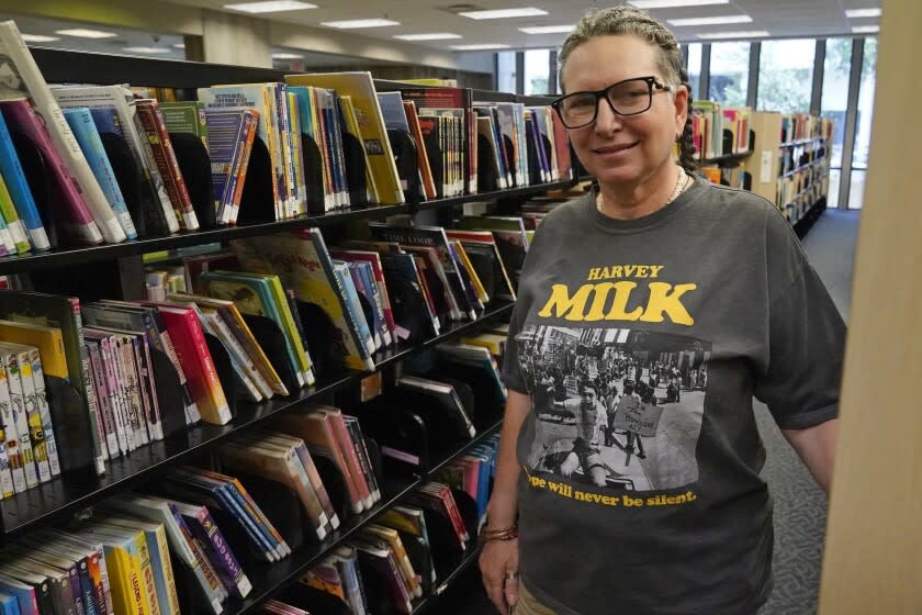 Gretchen Robinson, maestra lesbiana de una escuela del Orange County de la Florida, posa para una foto en la biblioteca de la escuela en Orlando el 13 de agosto del 2022. Robinson dice que una nueva ley sobre la enseñanza de la identidad de género y la orientación sexual "transmite un mensaje horrible. Tóxico. Discriminatorio". (AP Photo/John Raoux)