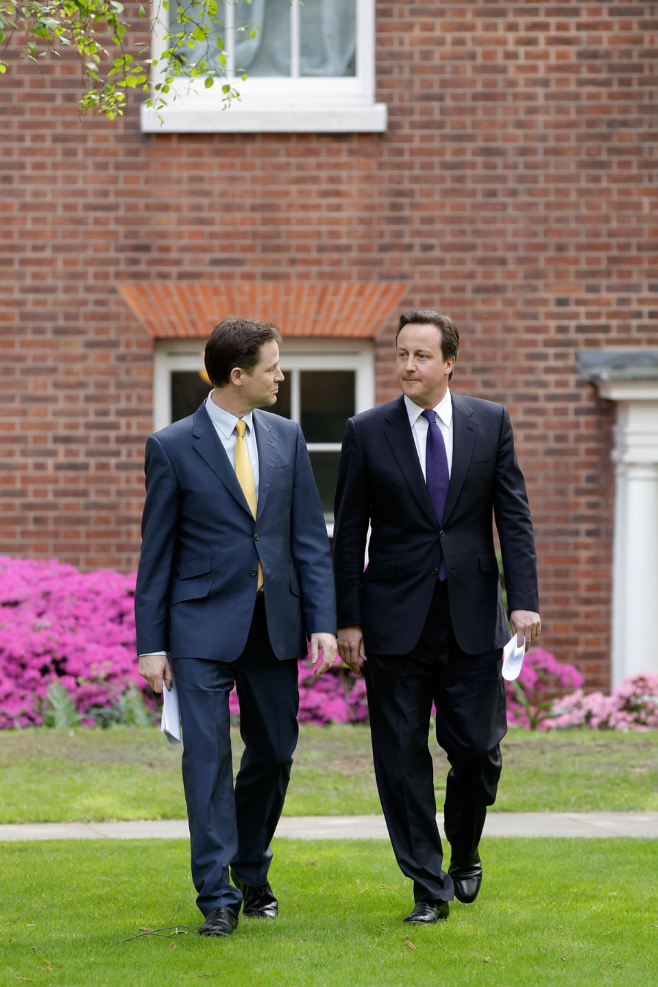 Prime Minister David Cameron (right) and Deputy Prime Minister Nick Clegg arriving to their first joint press conference in the Downing Street garden (PA)