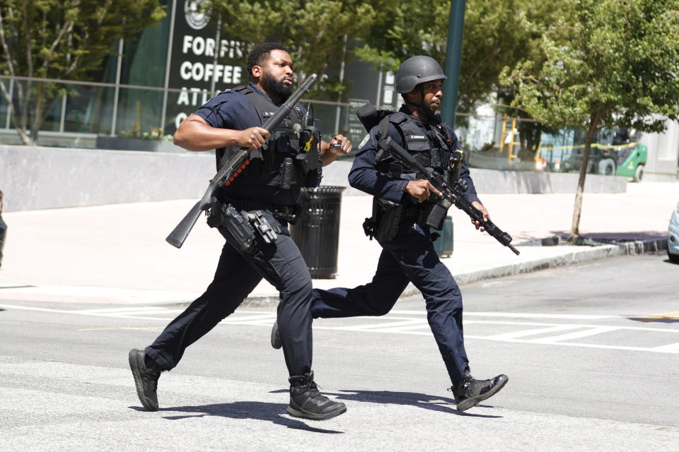 Law enforcement officers run near the scene of an active shooter on Wednesday, May 3, 2023 in Atlanta. Atlanta police said there had been no additional shots fired since the initial shooting unfolded inside a building in a commercial area with many office towers and high-rise apartments. (AP Photo/Alex Slitz)