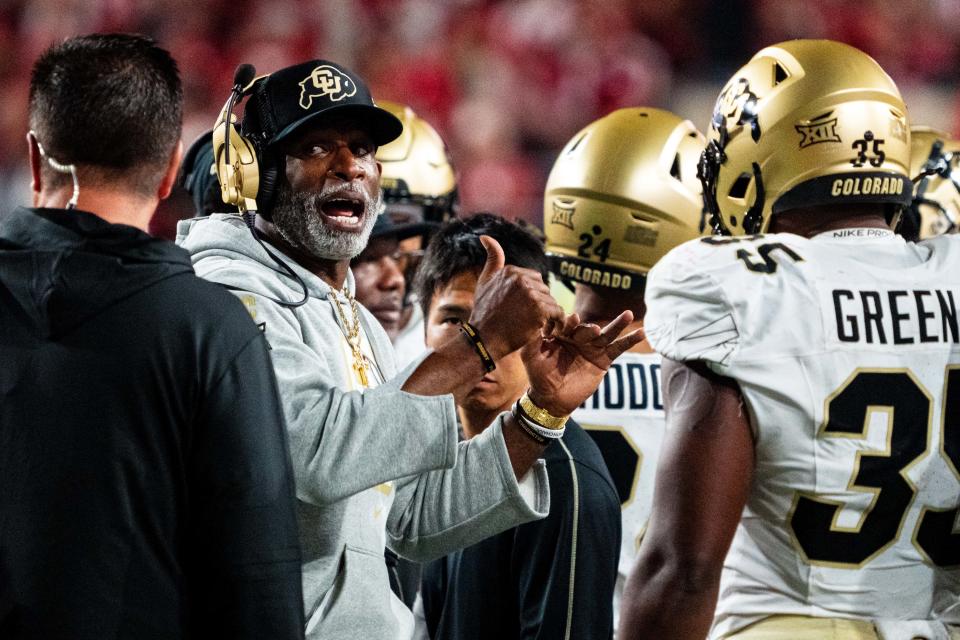 Colorado coach Deion Sanders talks with players during a timeout in the third quarter against Nebraska at Memorial Stadium.