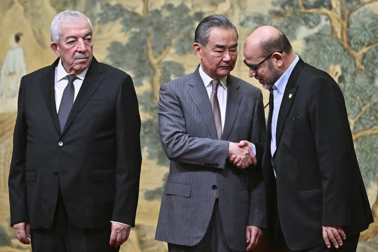 El Ministro de Relaciones Exteriores de China, Wang Yi (centro), en la firma del acuerdo entre Mahmud al-Alul, izquierda, vicepresidente de Fatah, y Mussa Abu Marzuk, un alto miembro de Hamas, en la Casa de Huéspedes Estatal Diaoyutai en Pekín. (Pedro Pardo/Pool Photo via AP)