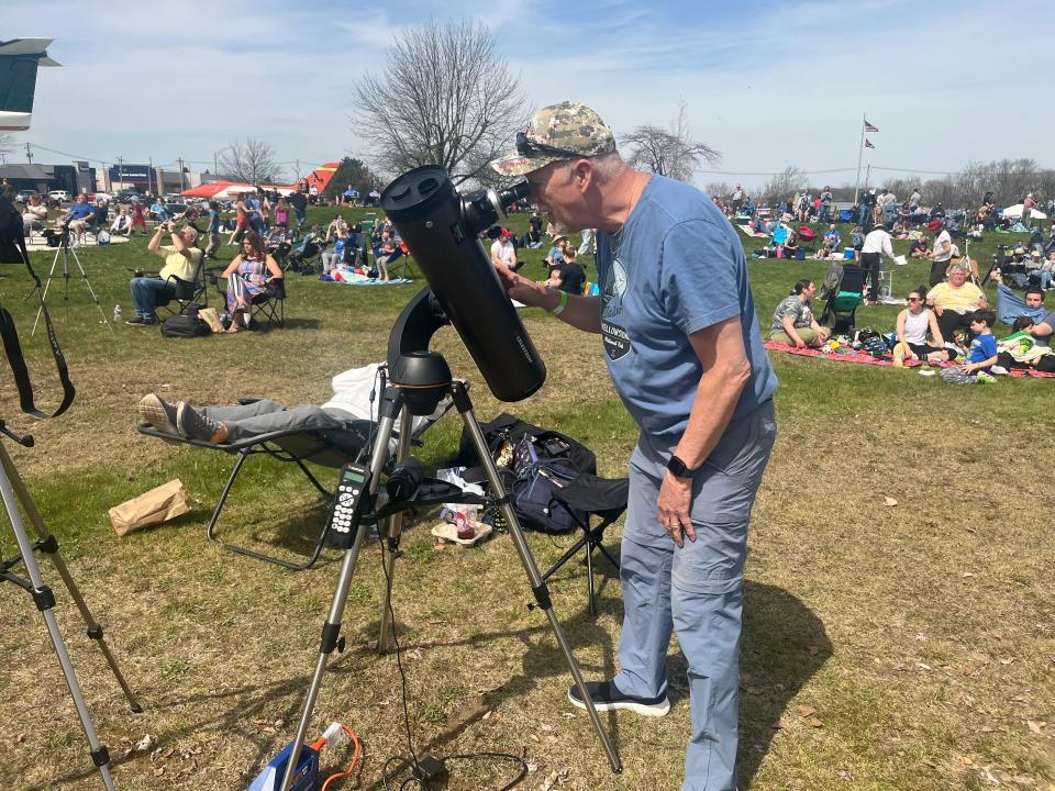 Doug Hansell, 67, from Minneapolis, Minnesota, looks through his telescope as the total eclipse begins at the Armstrong Air & Space Museum in Wapakoneta, Ohio on April 8, 2024