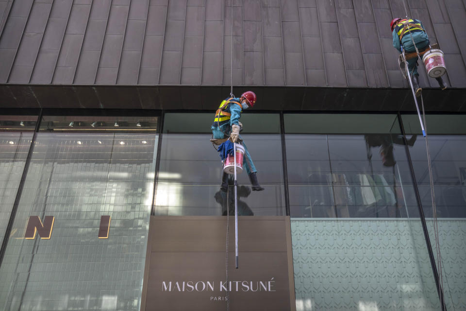 A window washer hangs from a rope line as he cleans at a shopping mall in Beijing, Tuesday, April 18, 2023. China’s economy grew 4.5% in the first quarter of the year, boosted by increased consumption and retail sales, after authorities abruptly abandoned the stringent "zero-COVID" strategy. (AP Photo/Mark Schiefelbein)