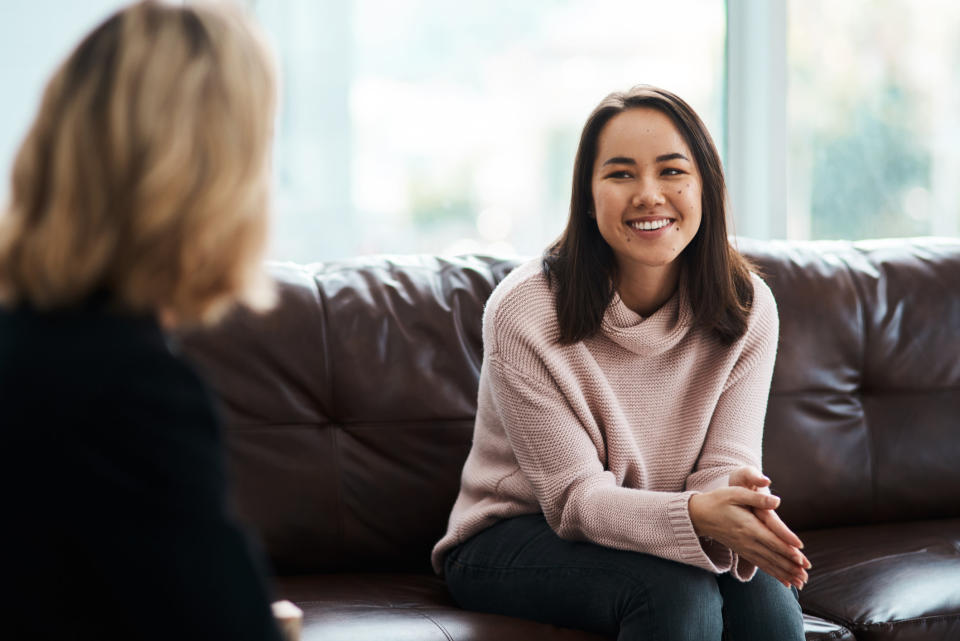 person talking to someone sitting on a couch