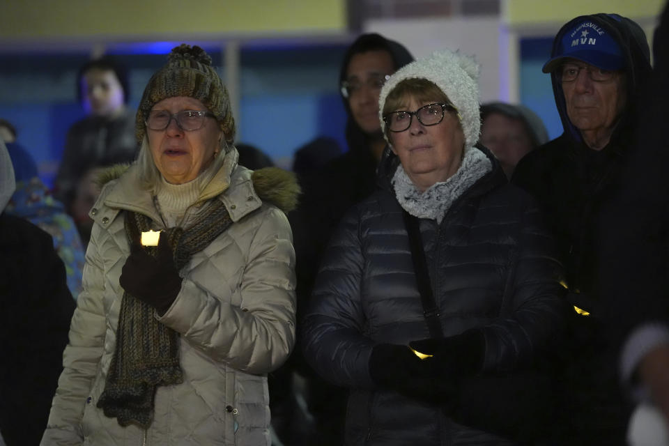 People attend a candlelight vigil after two police officers and a first responder were shot and killed Sunday, Feb. 18, 2024, in Burnsville, Minn. (AP Photo/Abbie Parr)