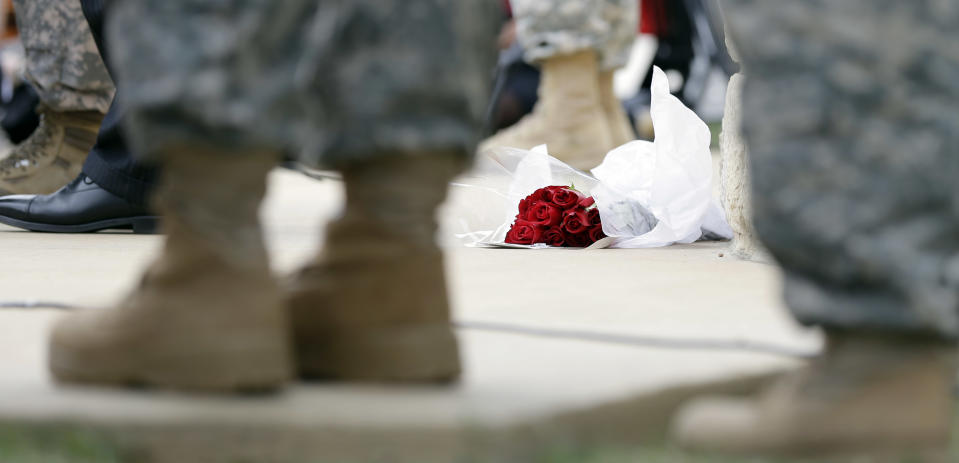 Roses left for shooting victims are seen at the feet of Lt. Gen. Mark Milley, U.S. Sen. John Cornyn, and other military during a news conference near Fort Hood's main gate, Thursday, April 3, 2014, in Fort Hood, Texas. A soldier opened fire Wednesday on fellow service members at the Fort Hood military base, killing three people and wounding 16 before committing suicide. (AP Photo/Eric Gay)