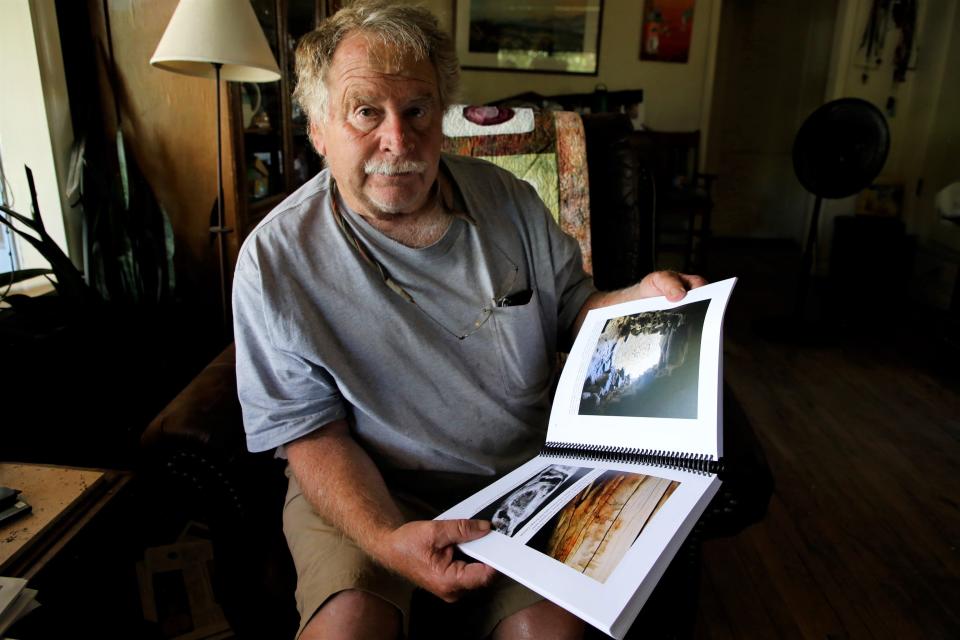 Fred Blackburn holds a copy of the 270-page report he and his research team put together outlining their three-year study of historic inscriptions at Aztec Ruins National Monument.