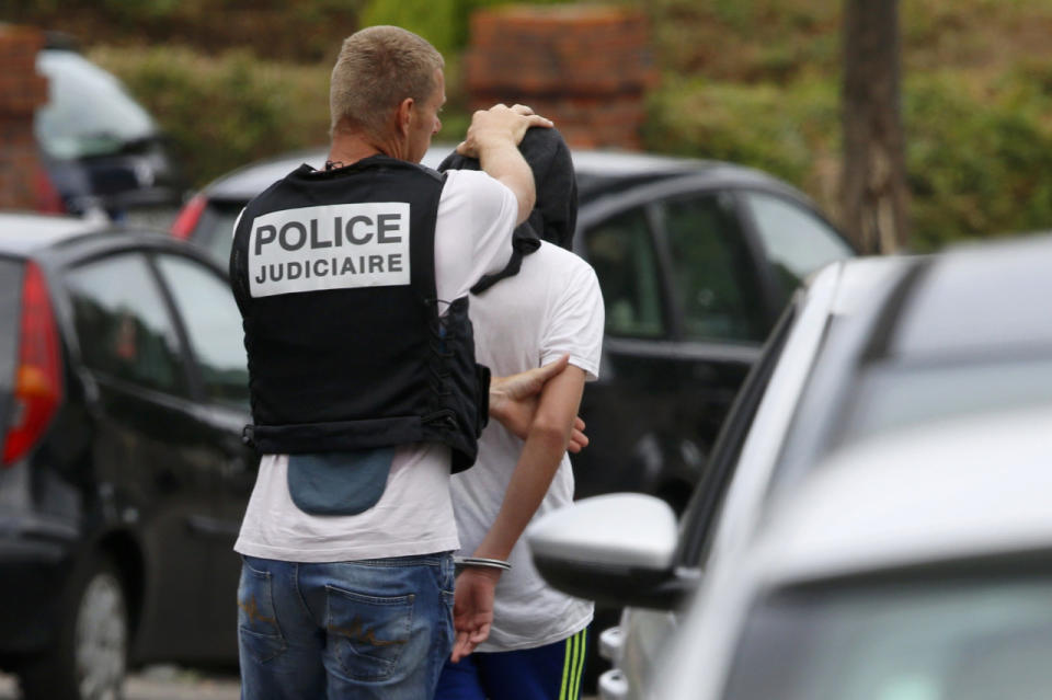<p>French judicial investigating police apprehends a man during a raid after a hostage-taking in the church in Saint-Etienne-du-Rouvray near Rouen in Normandy, France, July 26, 2016. (REUTERS/Pascal Rossignol)</p>