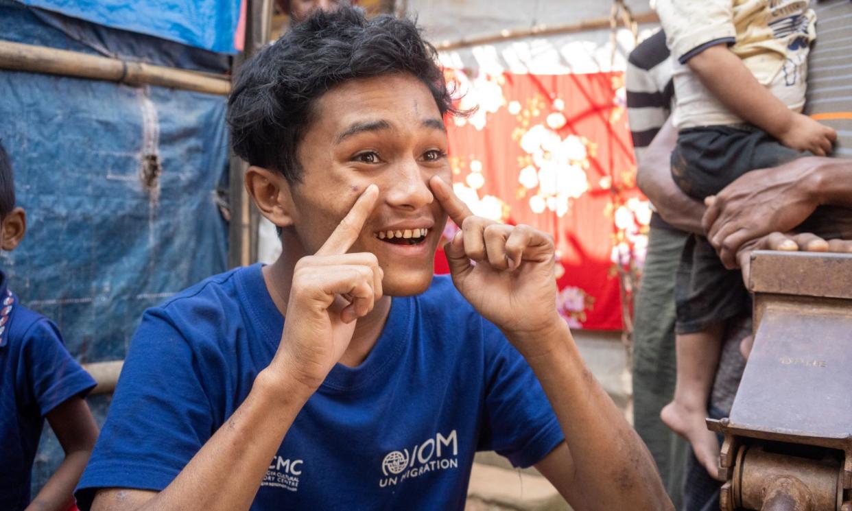 <span>With no chance to learn formal sign language, Asom Khan, who is deaf and mute, uses his own version to communicate with friends and family in Bangladesh.</span><span>Photograph: Kaamil Ahmed</span>