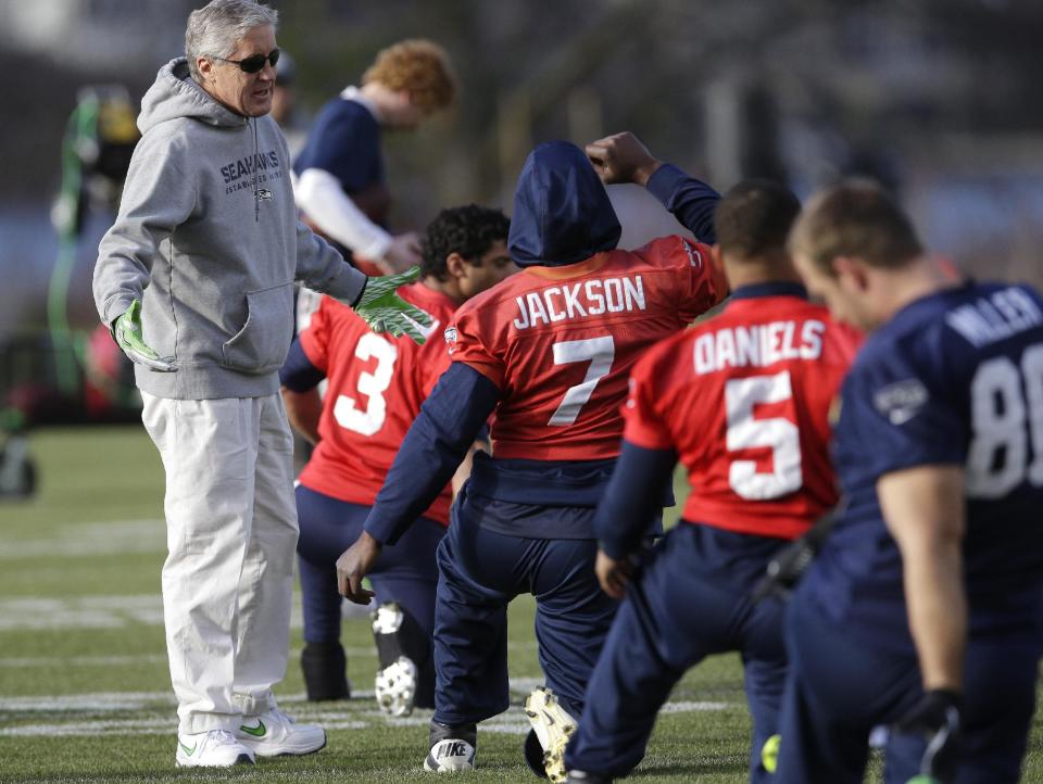 Seattle Seahawks coach Pete Carroll, left, talks with backup quarterback Tarvaris Jackson (7) during stretching drills before NFL football practice, Friday, Jan. 3, 2014, in Renton, Wash. Seattle plays at home in a playoff game on Jan. 11. (AP Photo/Ted S. Warren)
