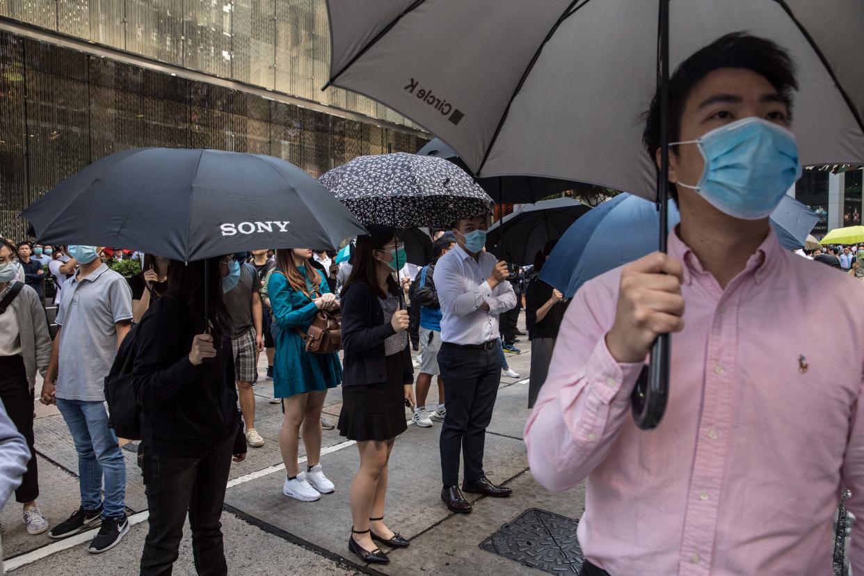 Protesters and office workers gather during a protest in the Central district in Hong Kong on November 13, 2019. - Pro-democracy protesters stepped up on November 13 a "blossom everywhere" campaign of road blocks and vandalism across Hong Kong that has crippled the international financial hub this week and ignited some of the worst violence in five months of unrest. (Photo by DALE DE LA REY / AFP) (Photo by DALE DE LA REY/AFP via Getty Images)