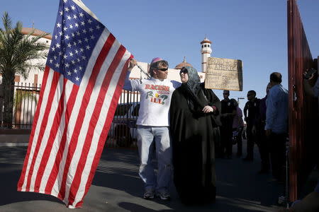 Two demonstrators stand in front of the Islamic Community Center to oppose the "Freedom of Speech Rally Round II" across the street in Phoenix, Arizona May 29, 2015. REUTERS/Nancy Wiechec