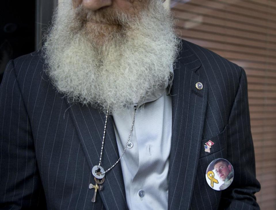 Keith Maupin, wears a pin with an image of his son, Sgt. Matt Maupin, in Arlington, Va.,Tuesday, May 13, 2014. A man in Iraqi custody has confessed to killing Sgt. Matt Maupin whose remains were found in 2008. Sgt. Matt Maupin, of Batavia in southwestern Ohio, was captured when insurgents with rocket-propelled grenades and small arms ambushed his fuel convoy near Baghdad on April 9, 2004. Keith Maupin decided to grow his beard until his son came home. He has never cut it. (AP Photo)