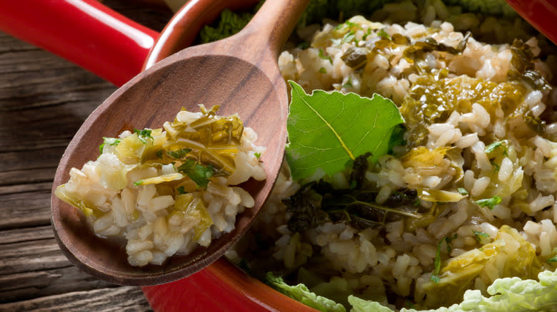 Spoonful of risotto with cooked salad greens