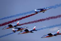 French aircrafts of the Patrouille de France spray colored smoke during a performance at the opening day of Dubai Airshow in Dubai, United Arab Emirates, Sunday, Nov. 17, 2019. (AP Photo/Kamran Jebreili)