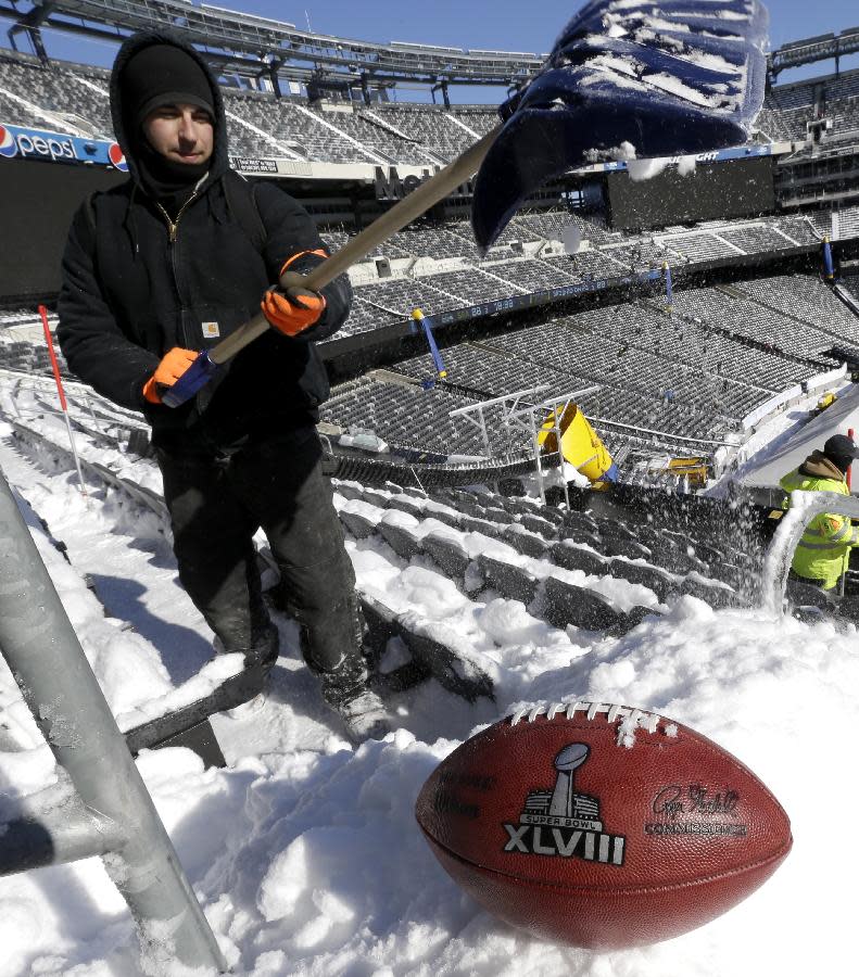 A football with the Super Bowl XLVIII logo is set on a mound of snow as an for an NFL photographer to make photos of it as workers shovel snow off the seating area at MetLife Stadium as crews removed snow ahead of Super Bowl XLVIII following a snow storm, Wednesday, Jan. 22, 2014, in East Rutherford, N.J. Super Bowl XLVIII, which will be played between the Denver Broncos and the Seattle Seahawks on Feb. 2, will be the first NFL title game held outdoors in a city where it snows. (AP Photo/Julio Cortez)