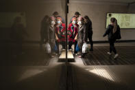 People, some of them wearing face masks to protect against coronavirus, are reflected in a marble wall of an underpass as they walk in Moscow, Russia, Monday, April 19, 2021. (AP Photo/Alexander Zemlianichenko)