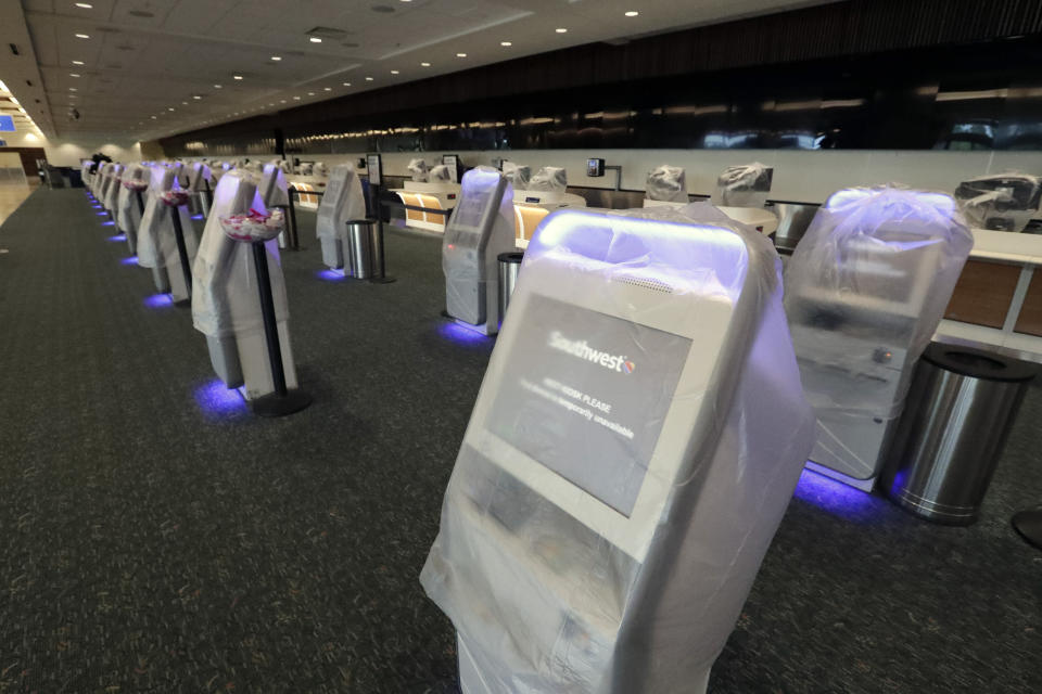 Self check in terminals and computers on the check in counter are covered in plastic at Orlando International Airport closed due to the anticipated arrival of Hurricane Dorian on the East Coast Tuesday, Sept. 3, 2019, in Orlando, Fla. (AP Photo/John Raoux)