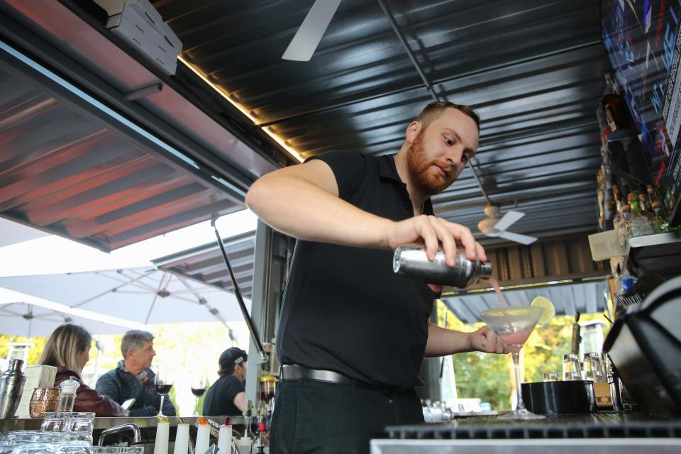 Bartender Mike Swift makes a pink grapefruit martini at the outdoor bar at 3 Restaurant in Franklin, Sept. 29, 2022.