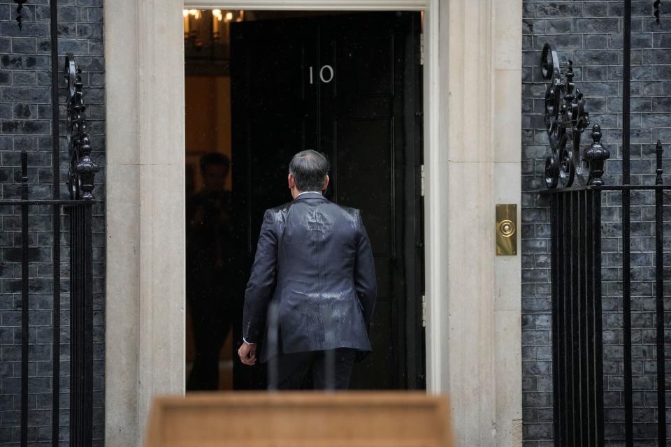 Rishi Sunak walks back into 10 Downing Street after his announcement (AP)