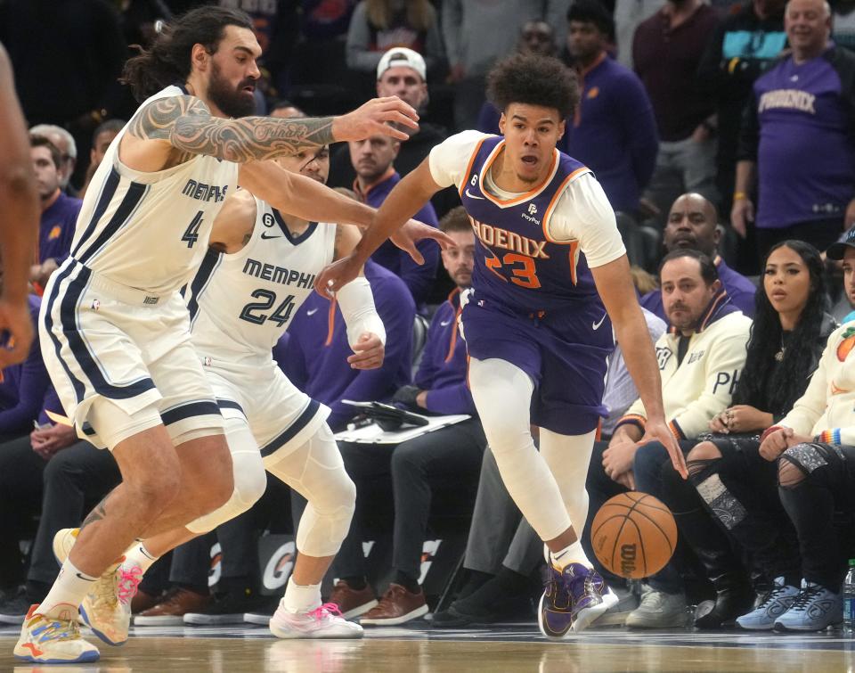 Phoenix Suns forward Cameron Johnson (23) dribbles away from Memphis Grizzlies center Steven Adams (4) to run out the clock at Footprint Center on Jan. 22, 2023.