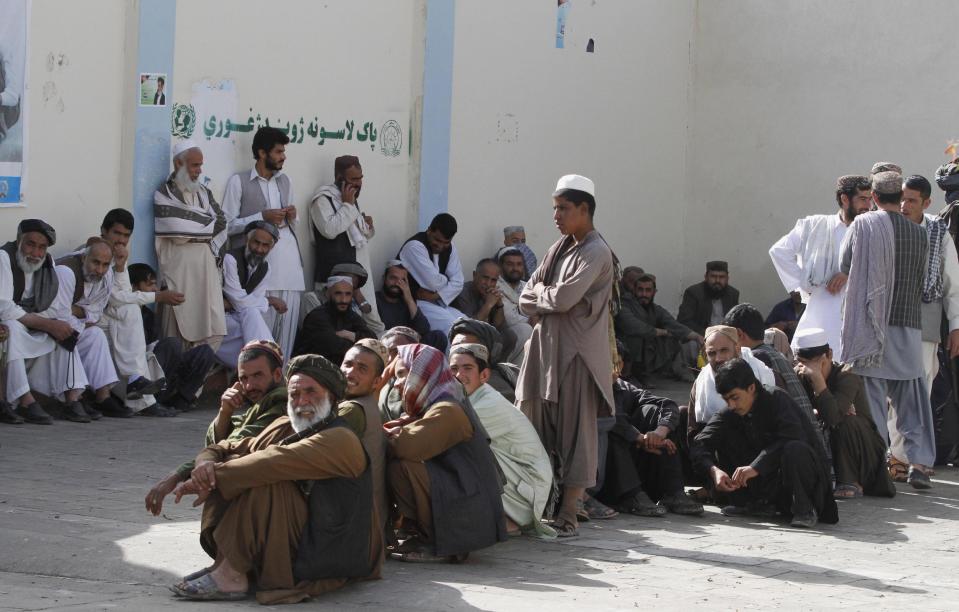 Afghan men line up for registration process before casting their votes at a polling station in Kandahar, Afghanistan, Saturday, April 5, 2014. Afghans flocked to polling stations nationwide on Saturday, defying a threat of violence by the Taliban to cast ballots in what promises to be the nation's first democratic transfer of power. (AP Photo/Allauddin Khan)