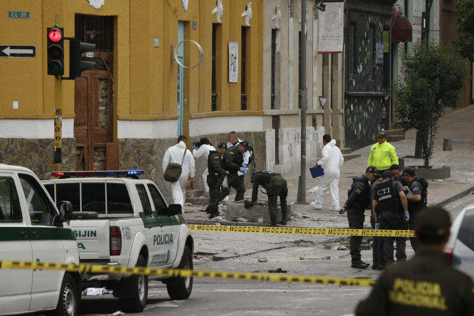 CORRECTS TO TWO DOZEN POLICE OFFICERS INJURED AND NO DEATHS - Police and investigators inspect the site where a homemade bomb exploded near the Santamaria bull ring in Bogota, Colombia, Sunday, Feb. 19, 2017. The artefact was detonated just a few hours before a scheduled bullfight, as police in riot gear were congregating ahead of a demonstration by animal rights activists. An official police statement said that 26 people suffered shrapnel and blast injuries, all but two of them officers. (AP Photo/Ricardo Mazalan)