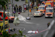 A covered body,foreground, lies on the street after a car crashed into a crowd of people in central Berlin, Germany, Wednesday, June 8, 2022. (AP Photo/Michael Sohn)