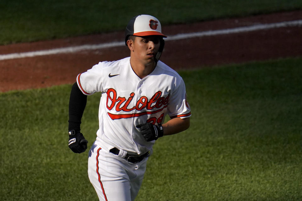 Baltimore Orioles' Ramon Urias heads to the dugout after hitting a two-run home run off Seattle Mariners starting pitcher Justus Sheffield during the fifth inning of the first game of a baseball doubleheader, Tuesday, April 13, 2021, in Baltimore. Orioles' DJ Stewart scored on the home run. (AP Photo/Julio Cortez)