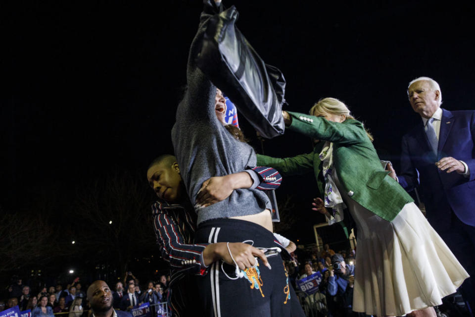 Former Vice President Joe Biden watches as his wife Jill Biden and his senior adviser Symone Sanders block a protester from arriving on stage during a primary night rally in the Baldwin Hills neighborhood of Los Angeles, Calif., on Tuesday, March 3, 2020. | Patrick T. Fallon/Bloomberg—Getty Images