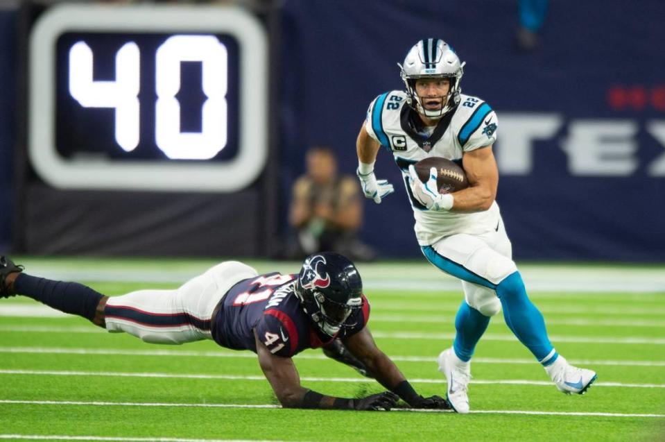 Panthers running back Christian McCaffrey, right, runs the ball during the game against the Texans at NRG Stadium on Thursday, September 21, 2021 in Houston, TX. McCaffrey suffered a hamstring injury during the second quarter and he did not return during the second half.