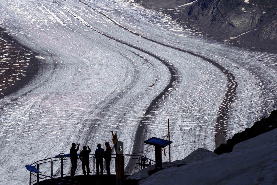 People enjoy the view at the Aletsch Glacier near Goms, Switzerland, Wednesday, June 14, 2023. (AP Photo/Matthias Schrader)