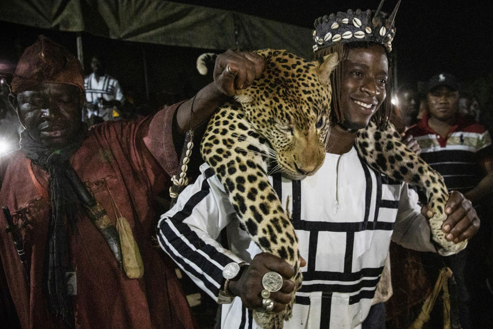 Members of the Association of Dozos of Dafra carry the body of a leopard during a celebration of their culture in Bobo-Dioulasso, Burkina Faso, 360 kilometers (220 miles) west of the capital, Ouagadougou, on Sunday, March 28, 2021. “Before someone faces a challenge, they know there are supernatural powers and spirits they can call upon in any situation,” said Jean Celestin Ky, professor of history at Joseph Ki-Zerbo University in Ouagadougou. (AP Photo/Sophie Garcia)