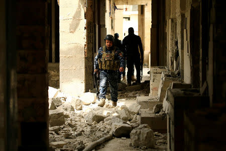 Federal police officers carry their weapons as they attempt to break into the Old City during a battle against Islamic State militants, in Mosul. REUTERS/Thaier Al-Sudani