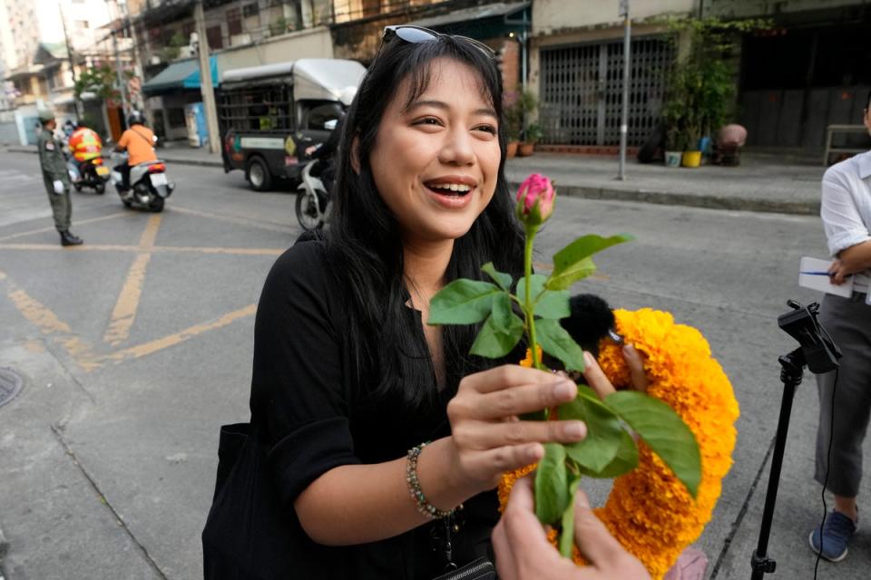 Patsaravalee Tanakitvibulpon receives a garland from her supporter on her arrival at Southern Criminal Court in Bangkok (AP)