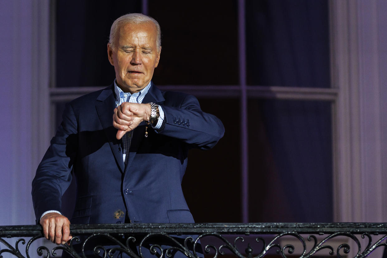  President Joe Biden looks at his wristwatch. 