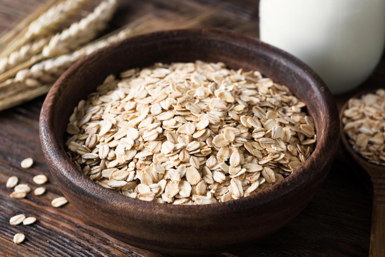 Rolled oats in wooden bowl on old wooden table. Rustic style. Healthy eating, healthy lifestyle, dieting and fitness menu concept