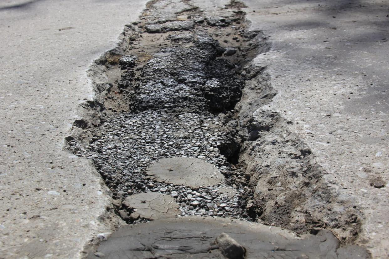 A pothole pictured on a Windsor road in a 2023 file photo.  (Mike Evans/CBC - image credit)