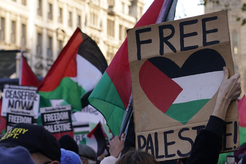 Manifestantes con banderas y pancartas realizan una manifestación propalestina en Whitehall, la calle de los edificios de gobierno en Londres, sábado 25 de noviembre de 2023. (AP Foto/Alberto Pezzali)