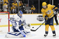 Nashville Predators right wing Luke Evangelista (77) tries to deflect the puck past Toronto Maple Leafs goaltender Joseph Woll (60) during the second period of an NHL hockey game Sunday, March 26, 2023, in Nashville, Tenn. (AP Photo/Mark Zaleski)