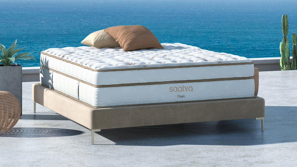 The Saatva Classic mattress photographed outside against a deep blue sea