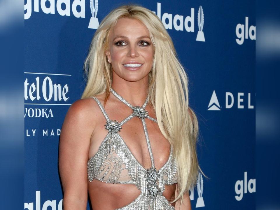 Sängerin Britney Spears auf einer veranstaltung, roter teppich, in einem glitzerkleid mit langen, offenen, blonden haaren 