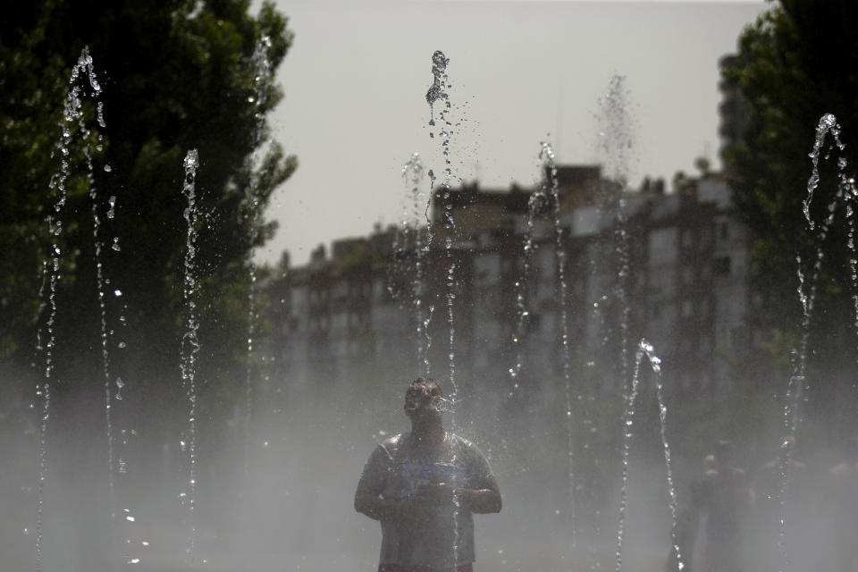 A man cools off in an urban beach at Madrid Rio park in Madrid, Friday, Aug. 3, 2018. Spain's Meteorological Agency says eight provinces in the southern Andalusia region and around Madrid are under high risk because of the heat wave hitting the country starting on Wednesday. (AP Photo/Francisco Seco)