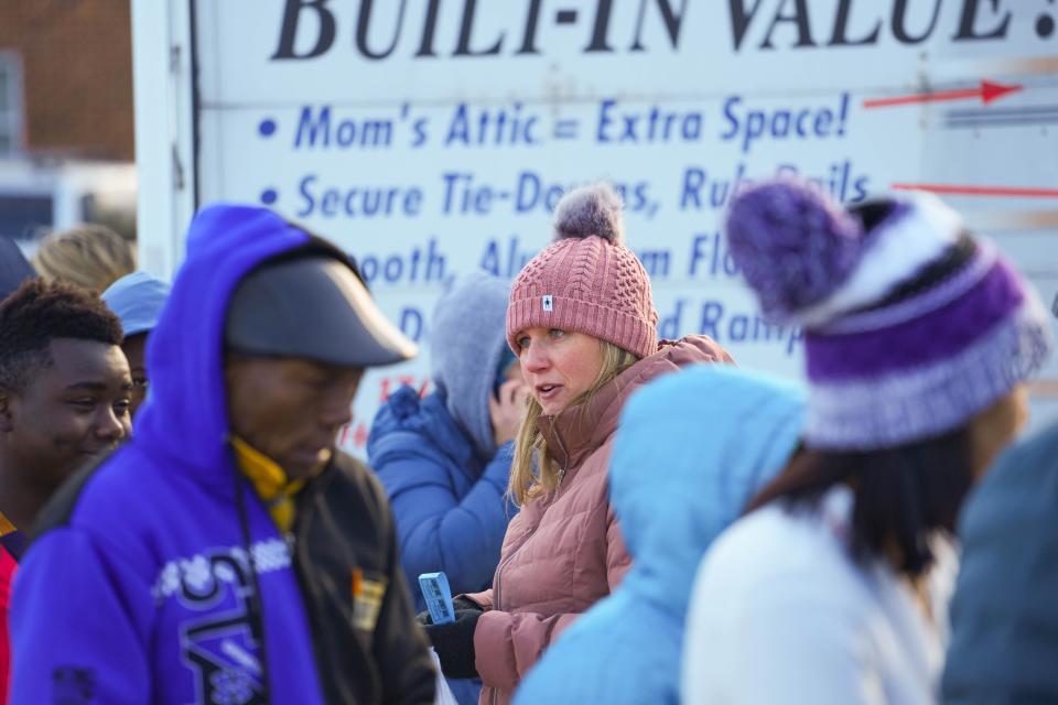 Volunteer Amy Beumer helps families at the Hickman Flats in Des Moines on Saturday. About 525 families attended Saturday's "Santa's Ride" event across six different locations in the city, with some families having up to eight people.