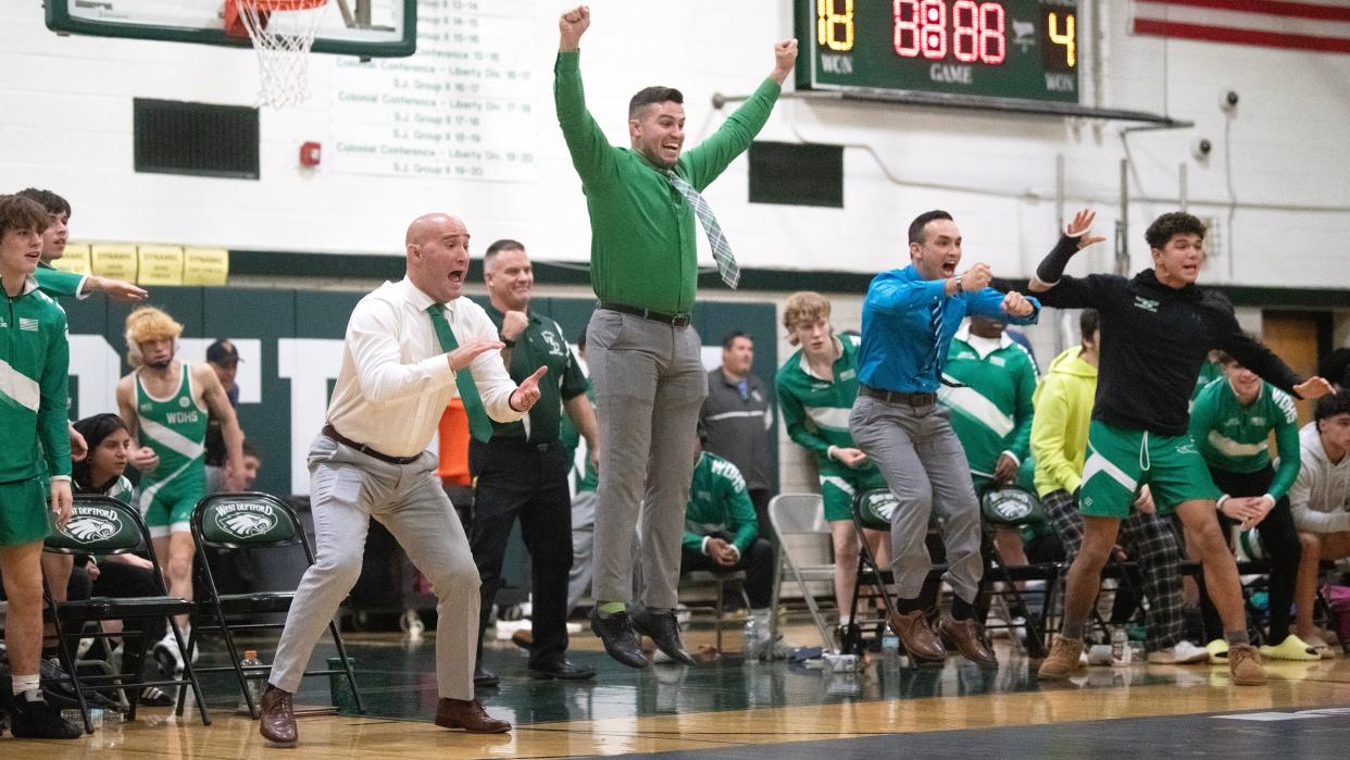 West Deptford High School's head wrestling coach James Shields, center, celebrates with his team as West Deptford's Anthony Catando pins Paulsboro's Audre Hill during the 120 lb. bout of the wrestling meet held at West Deptford High School on Thursday, January 4, 2024. West Deptford defeated Paulsboro, 53-16.