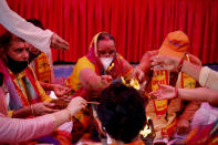 Hindus offer prayers for a groundbreaking ceremony of a temple dedicated to the Hindu god Ram in Ayodhya, at the Vishwa Hindu Parishad, or World Hindu Council, headquarters in New Delhi, India, Wednesday, Aug. 5, 2020. The coronavirus is restricting a large crowd, but Hindus were joyful before Prime Minister Narendra Modi breaks ground Wednesday on a long-awaited temple of their most revered god Ram at the site of a demolished 16th century mosque in northern India. (AP Photo/Manish Swarup)