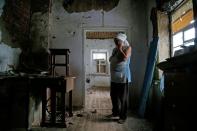 Una mujer reacciona al ver los daños causados en su casa de Vesele (Ucrania) el 27 de julio tras un enfrentamiento entre militantes de la autoproclamada República Popular de Donetsk y las fuerzas armadas de Ucrania. (Foto: Alexander Ermochenko / Reuters).