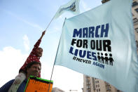 <p>People walk with signs during “March for Our Lives”, an organized demonstration to end gun violence, in downtown Los Angeles, California, U.S., March 24, 2018. (Patrick T. Fallon/Reuters) </p>