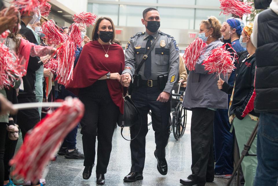 Manchester Township Police Lieutenant Antonio Ellis and his wife Carla Ellis are greeted by dozens of cheering Cooper University Health Care staff members as they enter Cooper University Hospital in Camden on Monday, November 22, 2021.  Lieutenant Antonio Ellis, who was among the first severe COVID-19 cases in New Jersey in mid-March 2020, returned to Cooper University Health Care to thank the team of caregivers who saved his life.